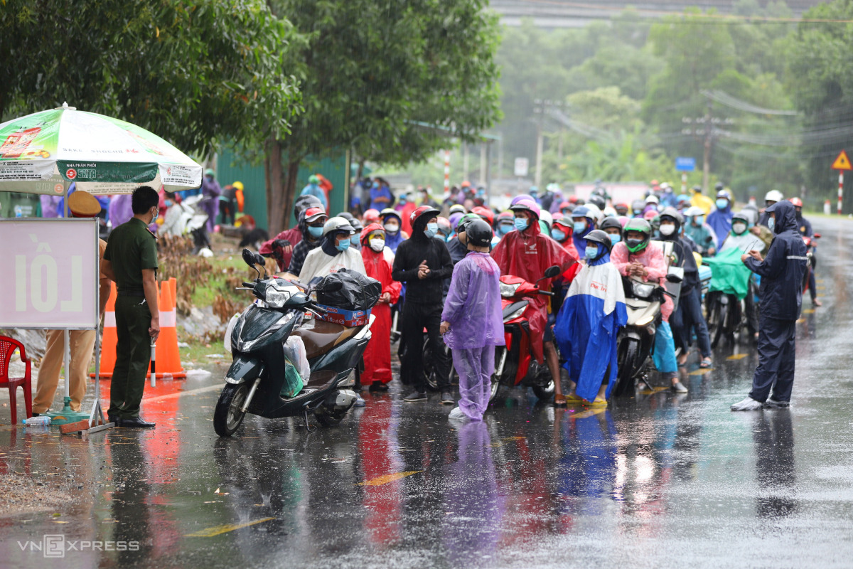 Người dân đội mưa chạy xe máy về quê