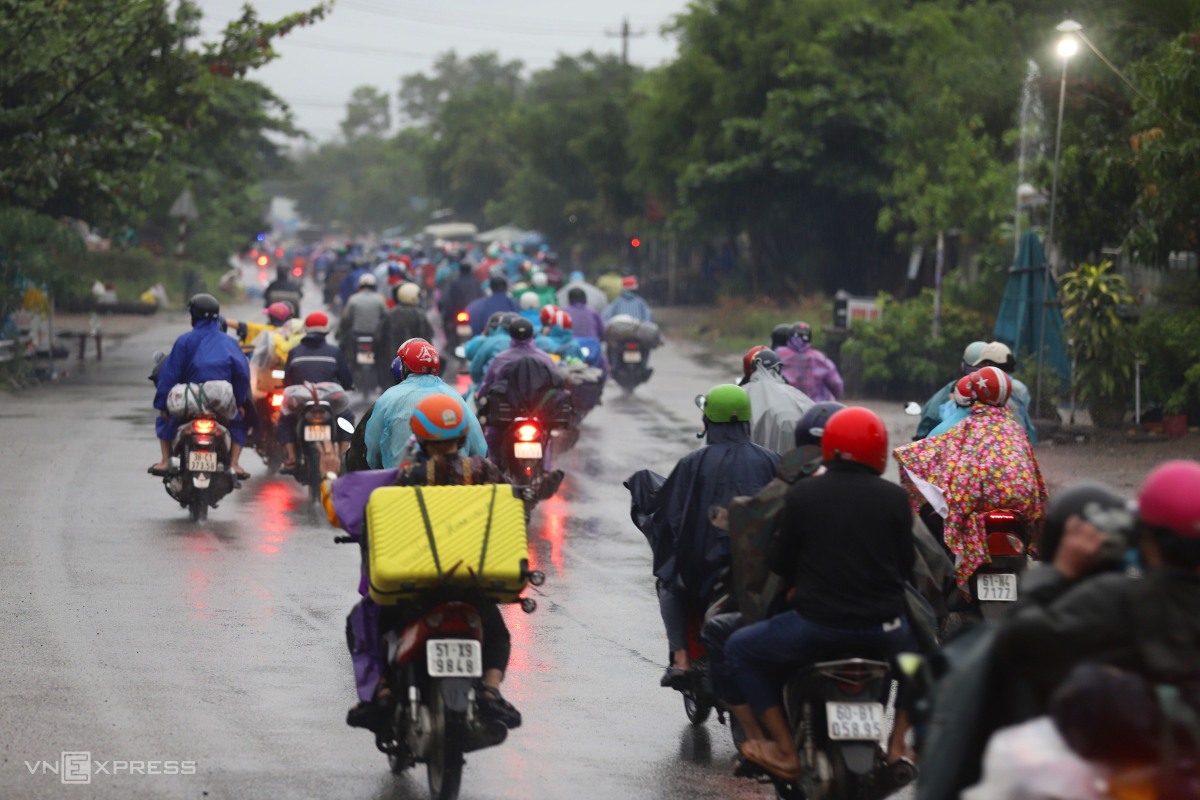 Người dân đội mưa chạy xe máy về quê