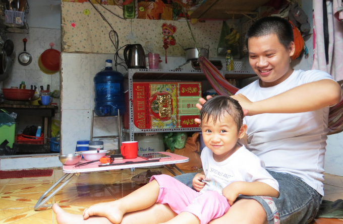 Anh Đức Phú chăm sóc con gái 3 tuổi khi vợ quay trở lại nhà máy. Ảnh: Lê Tuyết