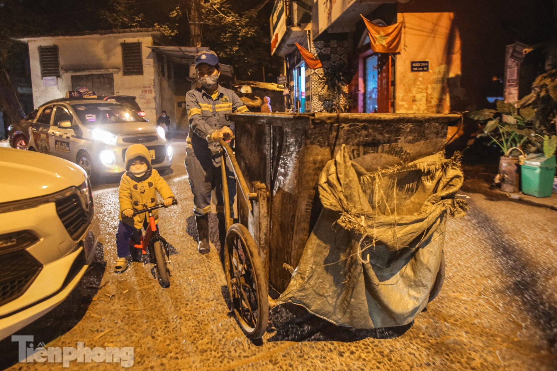 Bé trai 2 tuổi theo chân mẹ lao công đi gom rác trong đêm đông lạnh giá ảnh 2