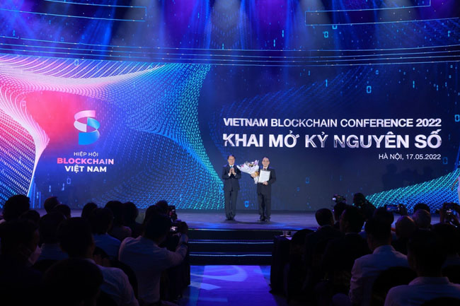 Ông Hoàng Văn Huây - Chủ tịch Hiệp hội Blockchain Việt Nam nhận hoa chúc mừng từ Thứ trưởng Bộ Nội vụ. 