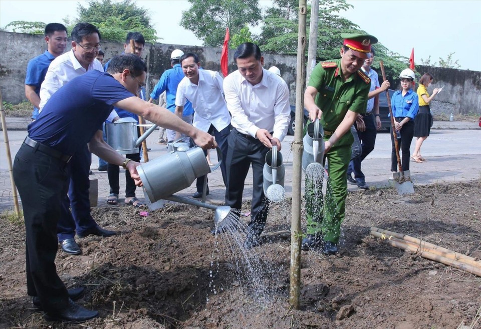 Các đại biểu tham gia trồng cây xanh tại các tuyến đường trong KCN Khánh Phú. Ảnh: NT
