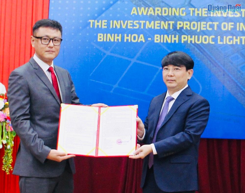 Trưởng Ban Quản lý KKT Dung Quất và các KCN tỉnh Hà Hoàng Việt Phương (bên phải) trao giấy chứng nhận cho nhà đầu tư.