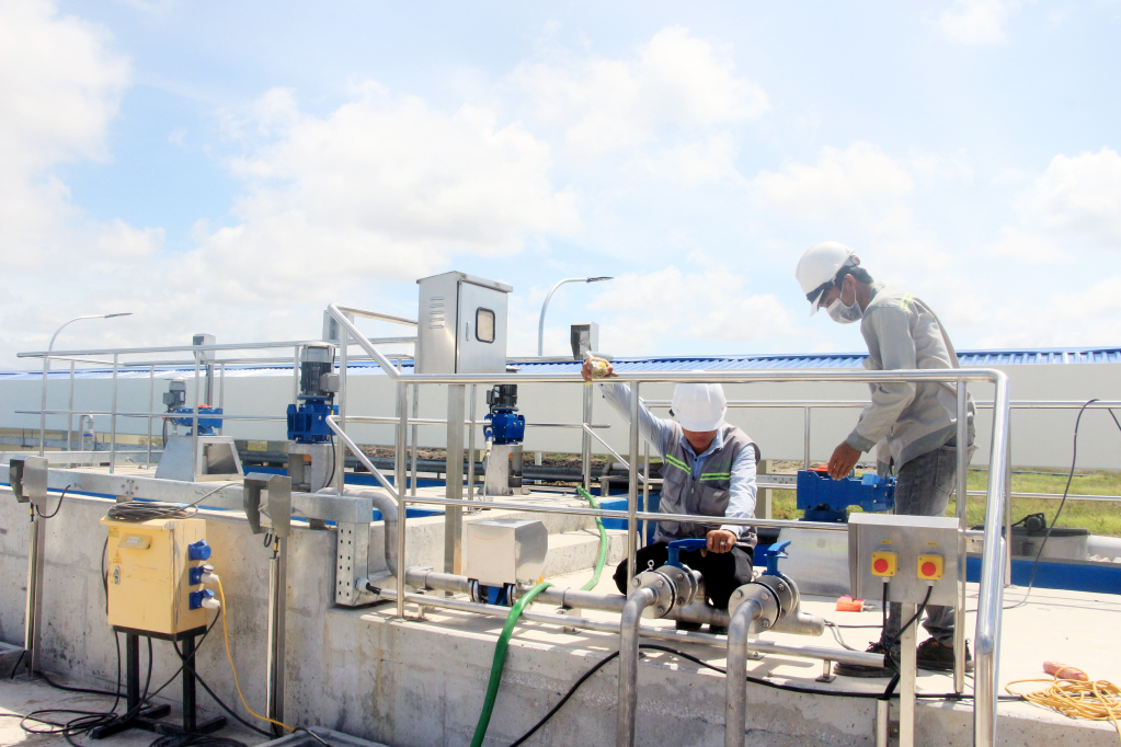 Công nhân lắp đặt hệ thống điện tại trạm xử lý nước thải KCN Nam Tiền Phong. Ảnh: Mạnh Trường