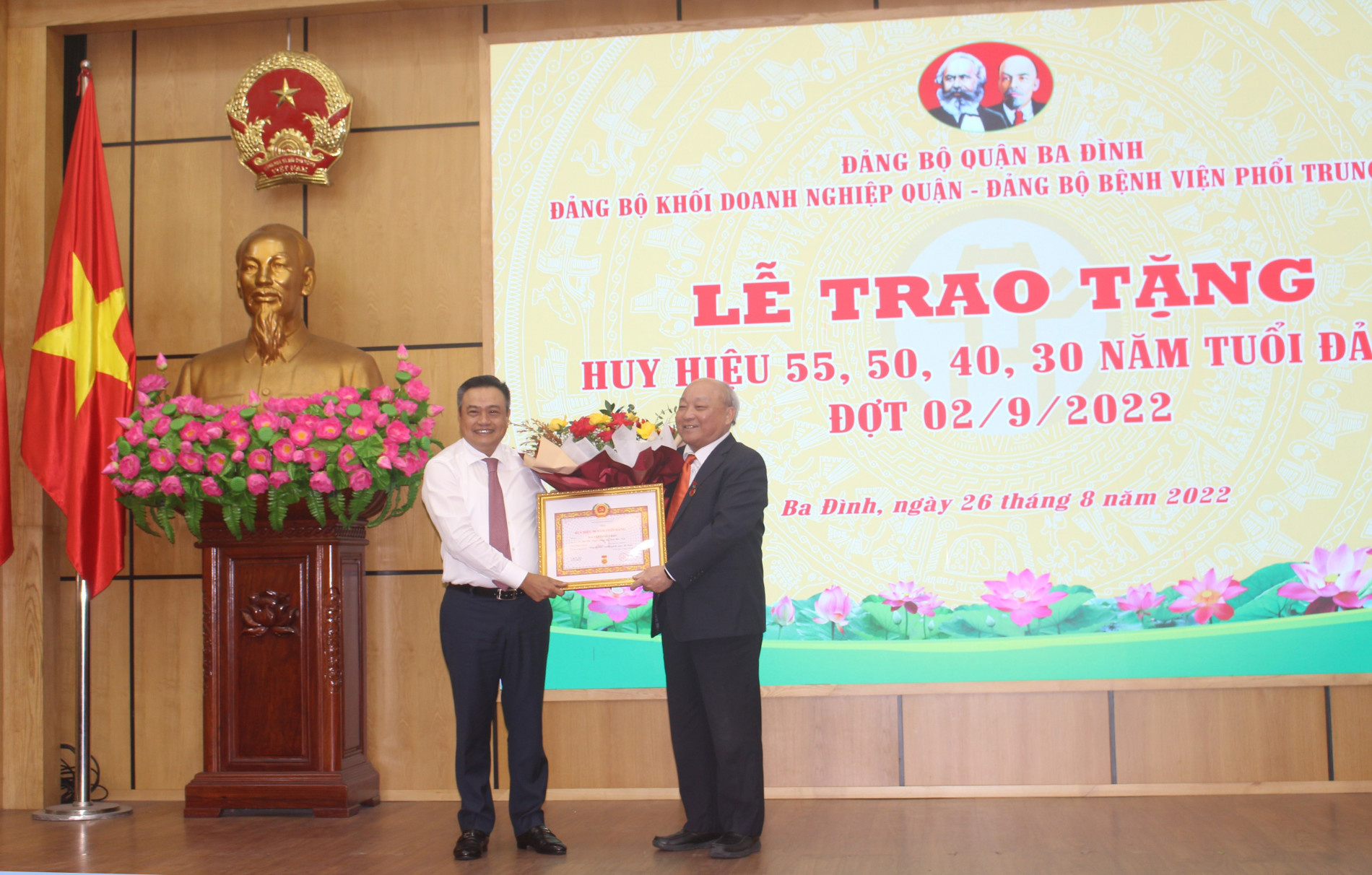 Chủ tịch UBND TP Trần Sỹ Thanh cũng tặng hoa ch&amp;uacute;c mừng đồng ch&amp;iacute; Nguyễn Quốc Triệu vinh dự nhận Huy hiệu 50 năm tuổi Đảng.