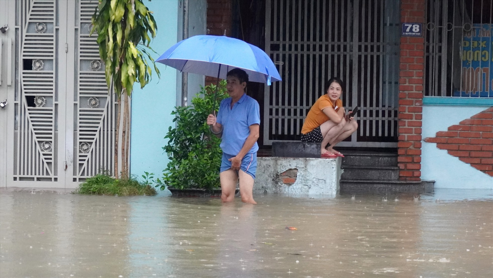 Người dân trên phố Nguyễn Nhữ Soạn, phường Phú Sơn di chuyển dò dẫm trong dòng nước. Ảnh: Q.D