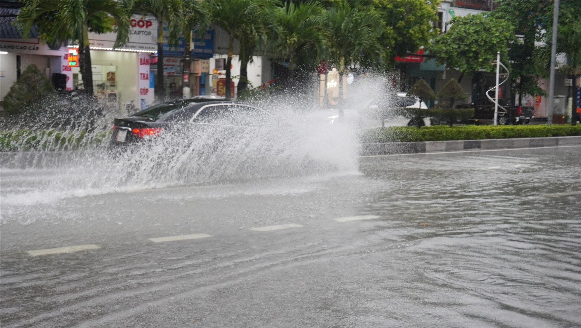 Chiếc xe con phi qua dòng nước ngập trên đường Bà Triệu, TP.Thanh Hóa. Ảnh: Q.D