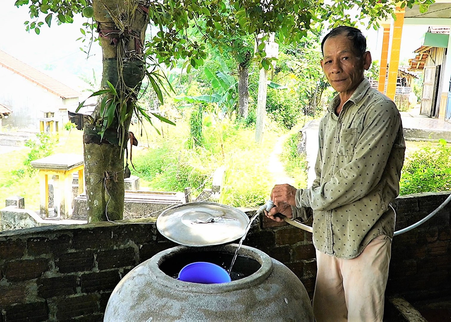 Ông Võ Văn Lai (ở thôn Trà Linh Đông, xã Hiệp Hòa, Hiệp Đức) sử dụng van tiết kiệm nước để chia sẻ nguồn nước cho cộng đồng. Ảnh: T.CHÂU