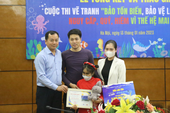 Ông Trần Đình Luân, Tổng cục trưởng Tổng cục Thủy sản, trao giải Lan tỏa cho em Tân Phương Nhi - tác giả bức tranh 'Vì một đại dương sạch đẹp và tràn đầy yêu thương'.