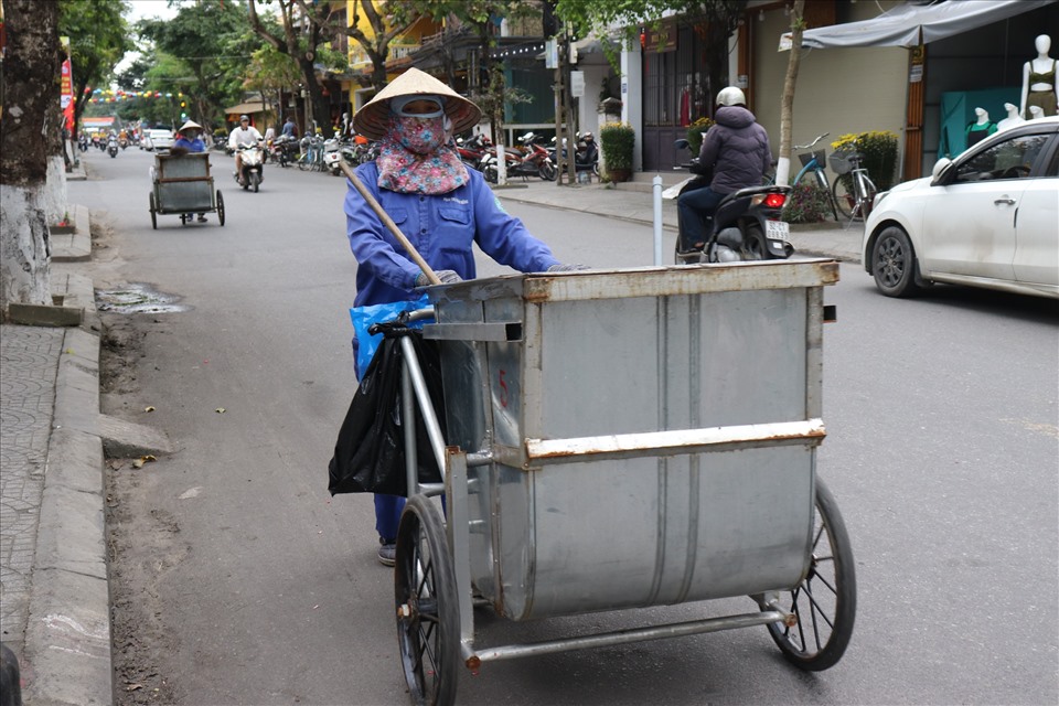 Những công nhân dọn vệ sinh môi trường vẫn lặng lẽ đi khắp các con đường để thu gom rác. Ảnh: Nguyễn Linh