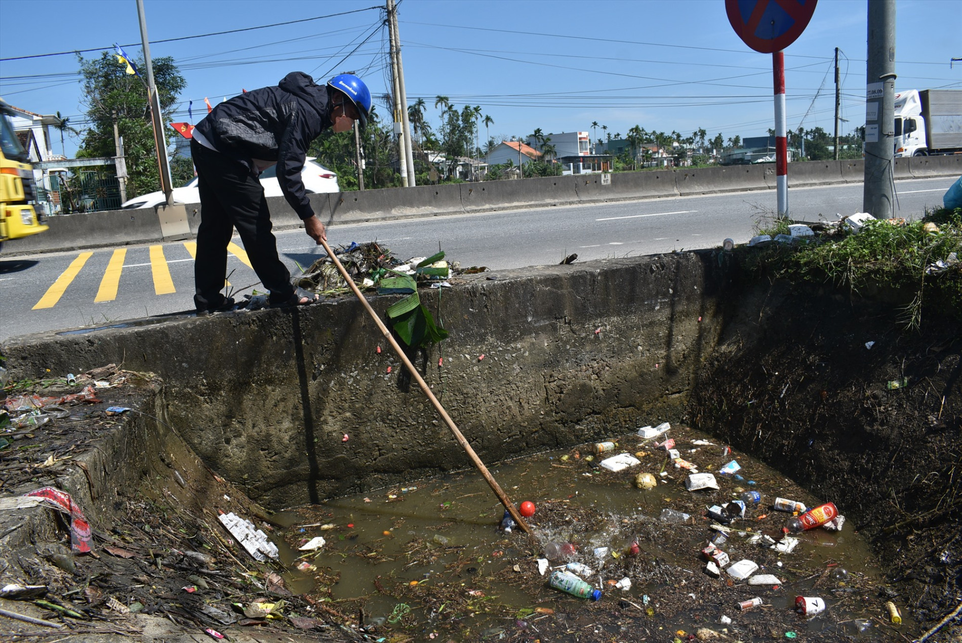 Cán bộ Công ty TNHH MTV Khai thác thủy lợi Quảng Nam đang vớt rác tại kên mương ở xã Tam Xuân 1 (Núi Thành).