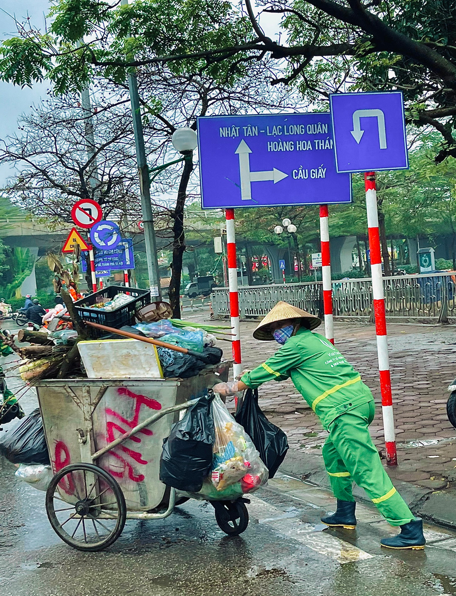 Những người lao công tận tâm trên khắp các con phố Hà Nội trong ngày mưa phùn giăng mắc - Ảnh 4.