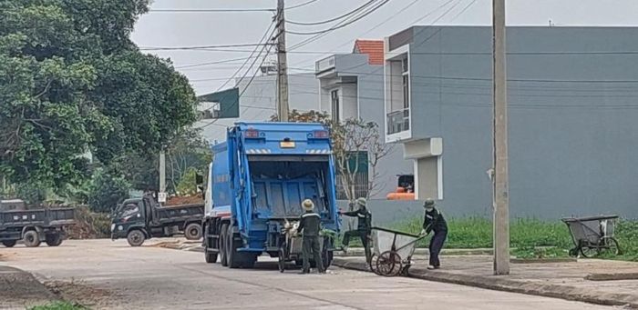Công nhân Công ty TNHH Xây dựng và Thương mại dịch vụ Bảo Linh thu gom rác thải sinh hoạt tại khu phố Ngô Quyền, thị trấn Quảng Hà.