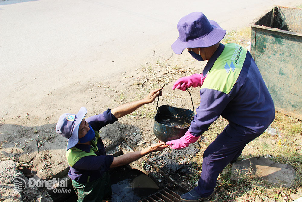 Công nhân Đội Công trình giao thông hốt bùn thải hệ thống mương dọc đường Nguyễn Văn Tỏ (P.Long Bình Tân, TP.Biên Hòa)
