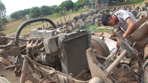 Một người thợ đang &quot;mổ&quot; xe tại thôn Thuyền vào năm 2013. Ảnh: Nhân Dân