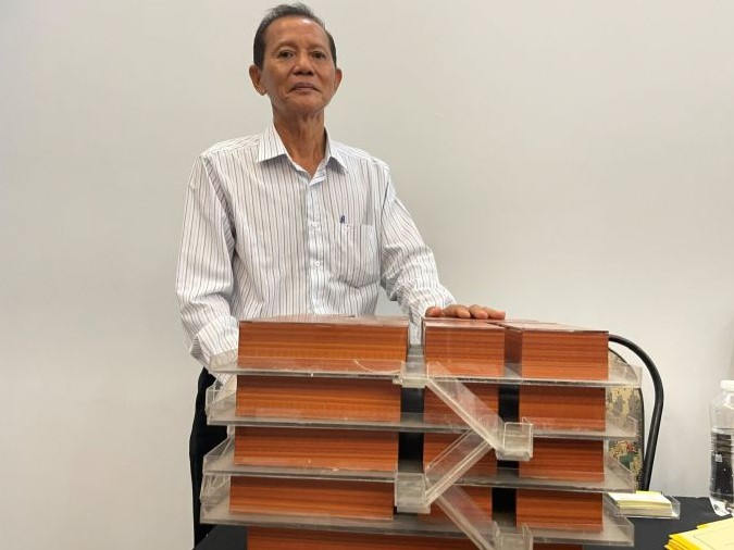Kỹ sư Trần Văn Tuấn (68 tuổi) bên mô hình cầu trượt thoát hiểm cho tòa nhà cao tầng