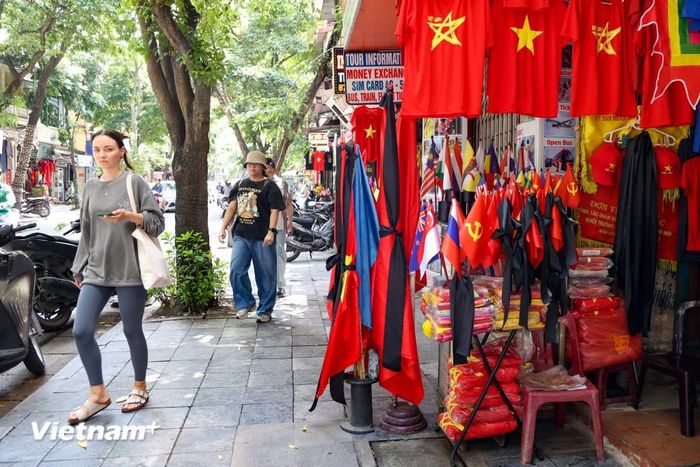  Một tiệm bán cờ trên phố Hàng Bông đang bày bán những lá cờ kèm băng quấn đen để bán cho khách. (Ảnh: Minh Hiếu/Vietnam+) 