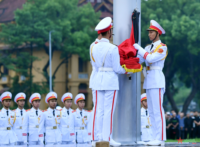 Đúng 6 giờ, lá Quốc kỳ có dải băng tang được kéo lên. Lễ thượng cờ rủ không có động tác tung Quốc kỳ thường thấy.