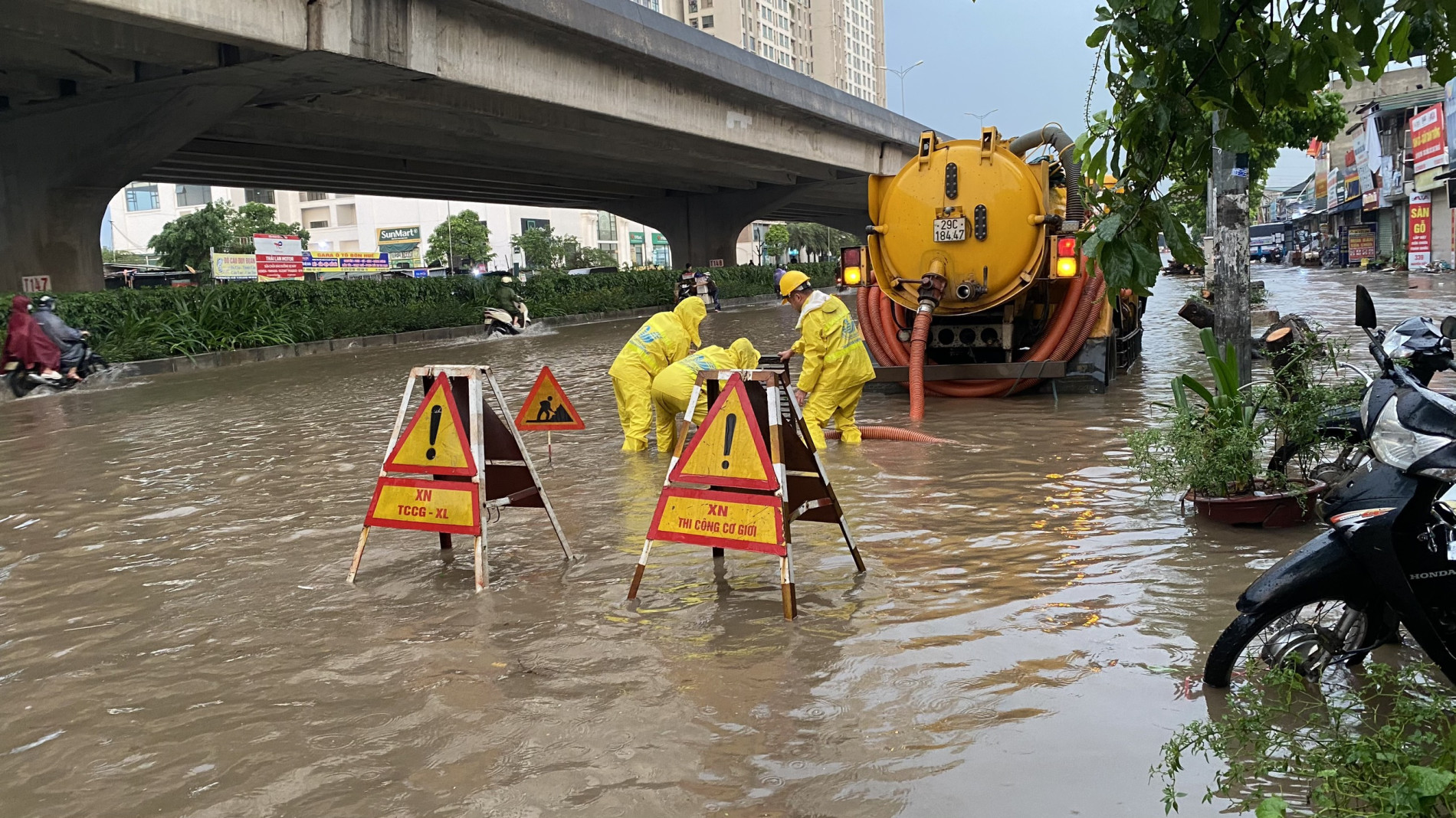 C&amp;ocirc;ng nh&amp;acirc;n tho&amp;aacute;t nước l&amp;agrave;m nhiệm vụ tr&amp;ecirc;n phố Nguyễn Xiển.