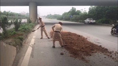 Cảnh sát giao thông Hà Nội quét dọn đất cát rơi trên đường